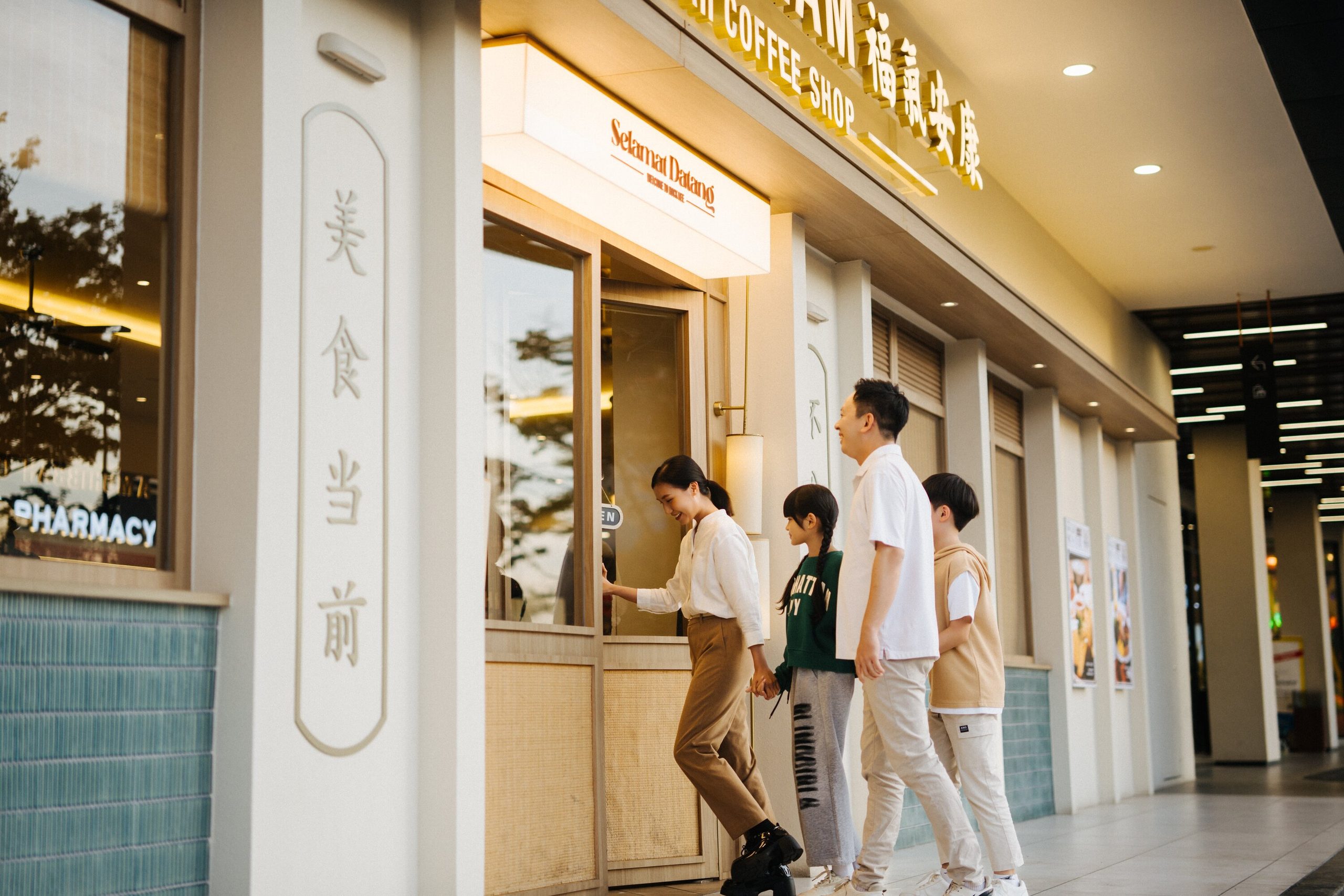 A family of four walking into a Hock Kee Kopitiam outlet